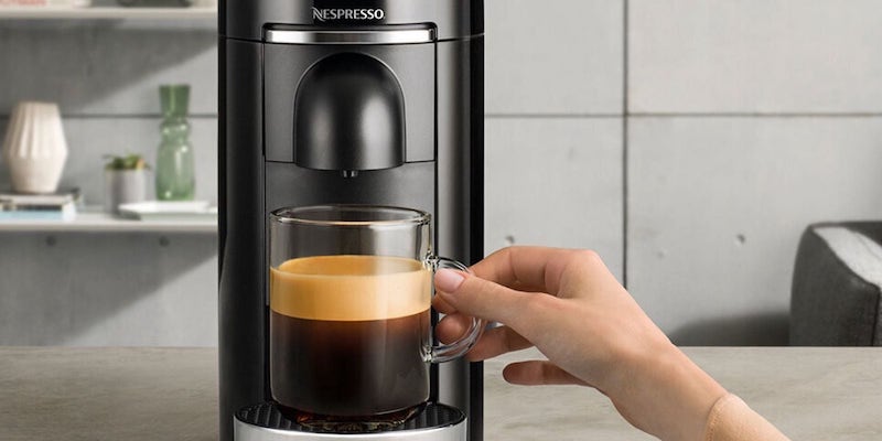 Breville Nespresso VertuoPlus Deluxe capsule coffee maker with a cup of coffee
